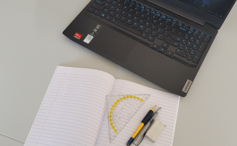 foto van pen en papier met een laptop er naast